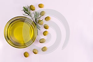 Plate with olive oil, rosemary and leaves on a white background. Copy space. Flat lay.