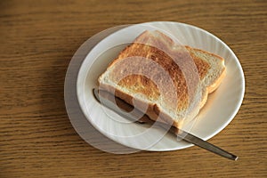 Plate of one toast with silver butter knife.