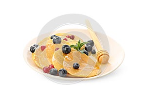 Plate with pancakes, dipper honey and berries isolated on white background