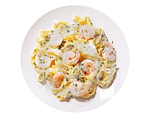 Plate of pasta fettuccine with cream sauce and shrimps isolated on a white background
