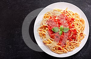 Plate of pasta with tomato sauce and green basil