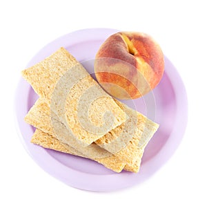 A plate with peach and three crisps