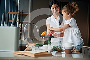 Plate with pepper. Mother with her daughter are preparing food on the kitchen