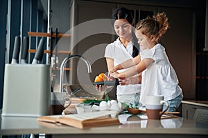 Plate with pepper. Mother with her daughter are preparing food on the kitchen