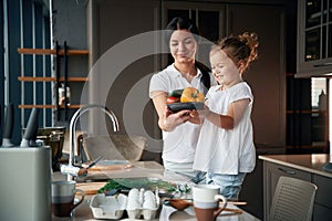 Plate with pepper. Mother with her daughter are preparing food on the kitchen