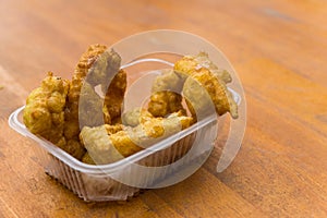 A plate of picarones with chicha morada at a street food market festival.