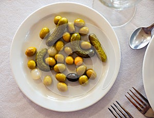 Plate with pickled olives, gherkins and baby onions