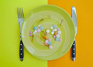 Plate of pills vitamins healthy pharmaceutical concept medicament a colored background