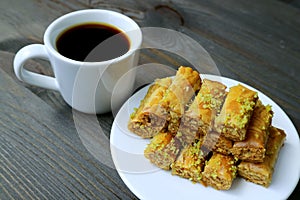 Plate of Pistachio Nuts Baklava Pastries with a Cup of Turkish Coffee Served on Wooden table