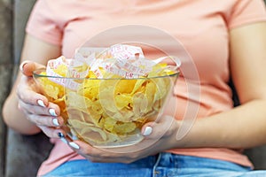 A plate of potato chips and a centimeter tape in the girl`s hands. Junk food. The concept of struggle against excess weight.