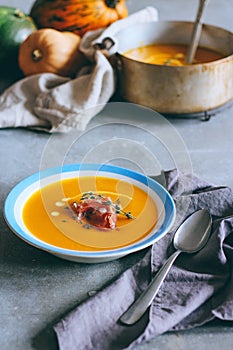 A plate of pumpkin soup with a jamon, garlic, thyme and cream