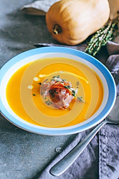 A plate of pumpkin soup with a jamon, garlic, thyme and cream
