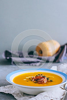 A plate of pumpkin soup with a jamon