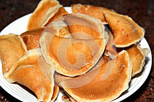 A plate of qatayef dumplings stuffed and filled with nuts and ready to be fried in deep oil and soaked with sugar syrup