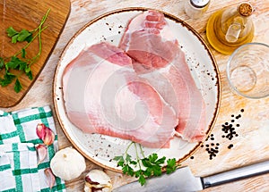 Plate of raw slice of Iberian pork secret and seasonings