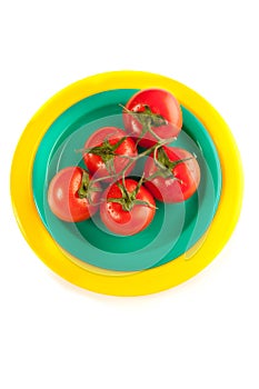 A plate of red tomatoes isolated on white