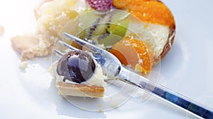 Plate with round fruit tart and fork