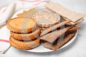 Plate of rye crispbreads, rice cakes and rusks on white checkered table