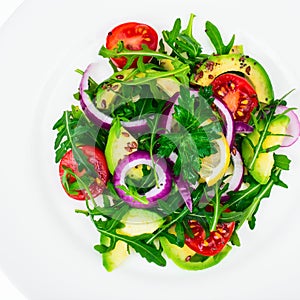 Plate with salad of fresh vegetables with avocado, isolated on white background