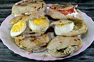 A Plate with Sandwiches of Feta white cheese with slices of tomatoes, traditional plain tahini halva or Halawa Tahiniya and slices