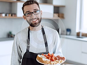 Plate of sandwiches in the hands of an attractive man