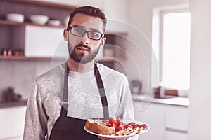 plate of sandwiches in the hands of an attractive man