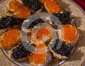Plate with sandwiches with red and black caviar
