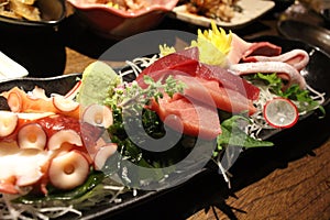 Plate of sashimi, filled with fish, octopus, and wasabi