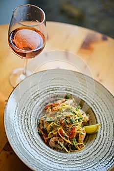 Plate of sea food, spicy pasta with shrimps and a glass of wine