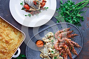 Plate with seafood, King prawns and squid, Fish menu in the restaurant, Dark background