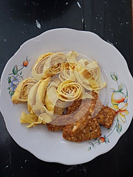 A plate of side dishes consists of omelet and fried tempeh