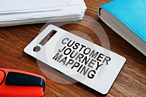 Plate with sign Customer journey mapping and papers with map photo