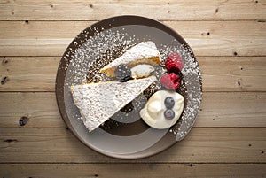 plate with slice of cake with fruits over wooden table