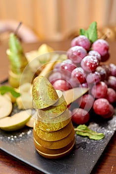 Plate with sliced fruits on servered buffet table at luxury wedding reception indoors, copy space.