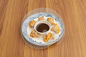 Plate of small tori katsu chicken bites with dipping sauce on white