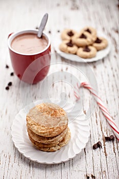 Plate of snickerdoodle cookies and hot chocolate on weathered white wood