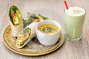 Plate of soup sandwich wrap lunch juice smoothie