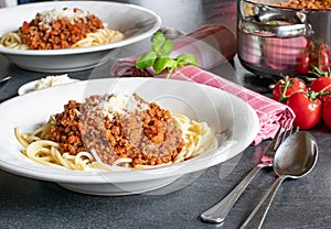 A plate of spaghetti bolognese with rasped parmesan cheese