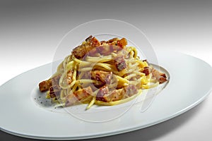 Plate of spaghetti carbonara on a white background