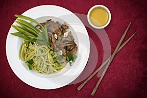 Plate of spaghetti dough with spinach and oyster mushrooms. Italian cuisine, Italian recipes. Wooden background. Top view. Close-u