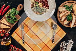 plate with spaghetti, fork and spoon on table