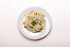 Plate of spaghetti prepared from zucchini and mushroom sauce on wooden table