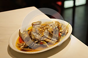 A plate of spicy solen clam on dinner table.