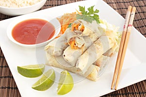 A plate of spring rolls with sweet and sour sauce