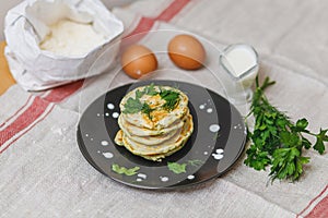 Plate with stack of fried pancakes and ingridients on table