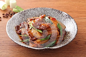 Plate of stewed pork with onion and green bean on the table