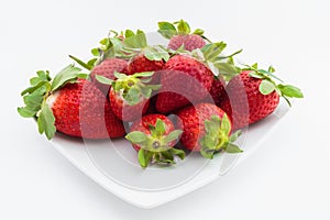 Plate of strawberries on white background photo