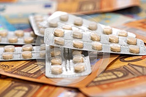 Plate with tablets on the euro bills, concept of expensive cost of healthcare or financing medicine