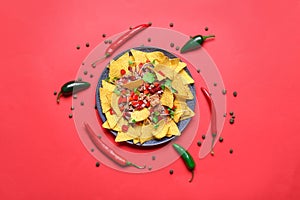 Plate with tasty chili con carne and nachos on color background photo