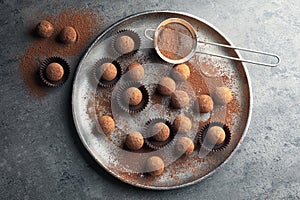 Plate with tasty chocolate truffles on grey background